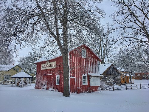Carriage house, red frame barn in winter