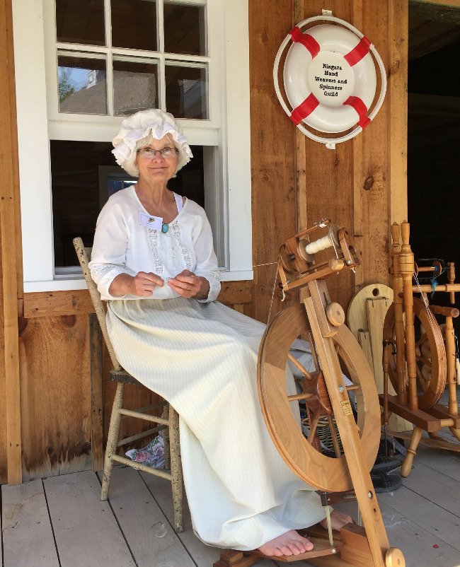 Woman demonstrates spinning wheel