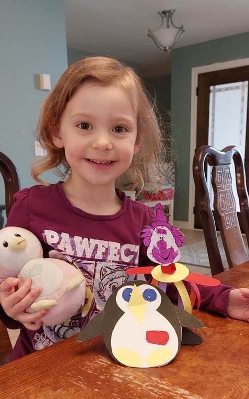 Child showing Penguin and Clown crafts