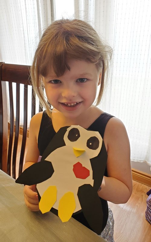 Child showing Penguin craft