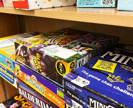 Several board games stacked on a shelf