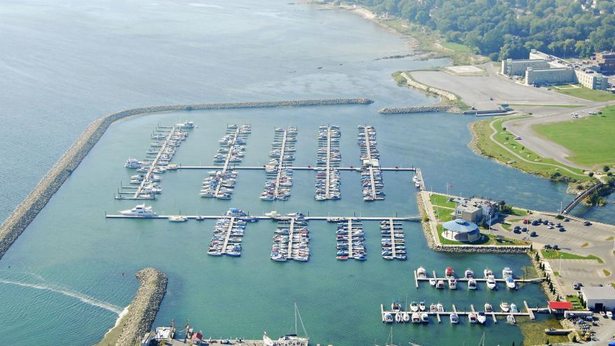 Aerial view of a marina with numerous boats docked in a calm, blue water setting.