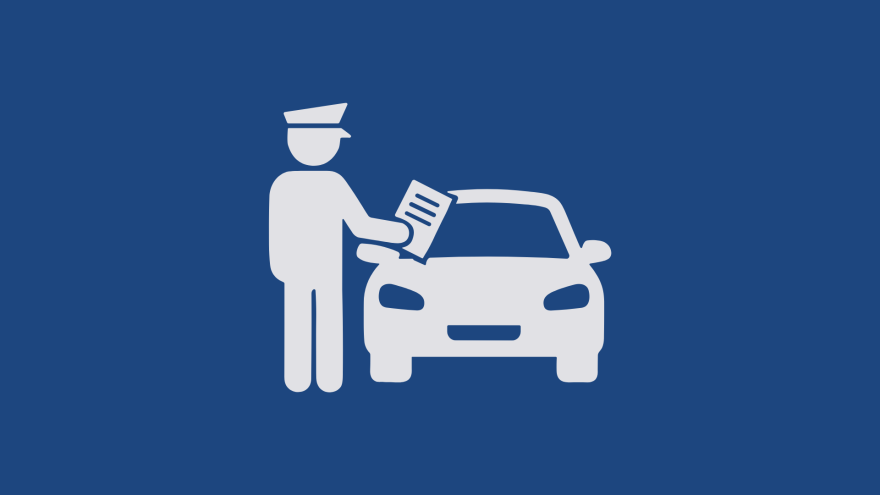 a person in uniform interacting with a car at a traffic stop.