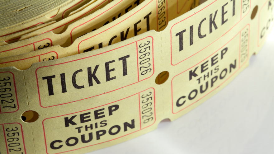 Roll of vintage tickets with red and black text on a beige background.