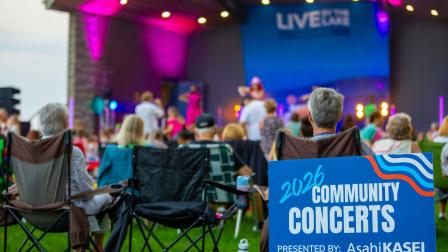 people in lawn chairs watching band on stage