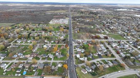 Aerial view of a small town with residential areas and tree-lined streets in autumn.