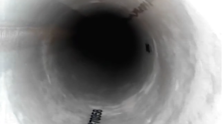 View into a dark pipe showing a distant interior with marked distance measurements.