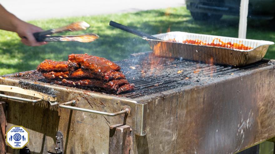 Barbecue grill with ribs cooking over flames.