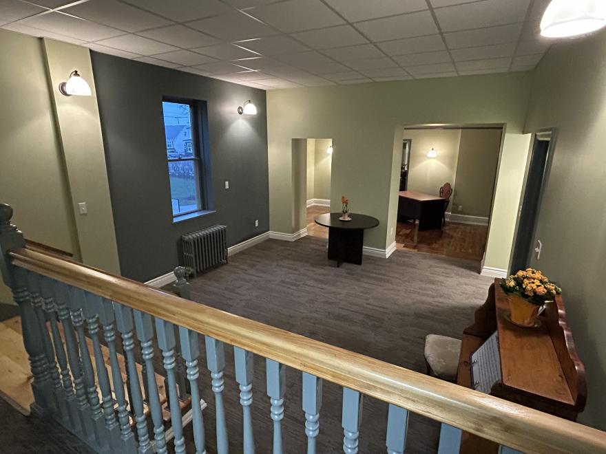 Spacious interior with green walls, carpeted floor, and decorative furniture.