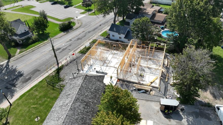 Aerial view of a construction site with a wooden framework on a concrete foundation.