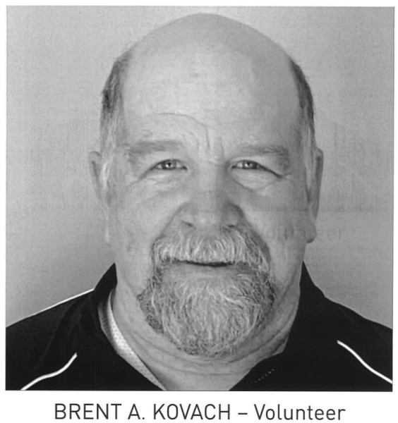 Black and white portrait of a smiling person with a beard, labelled as a volunteer.