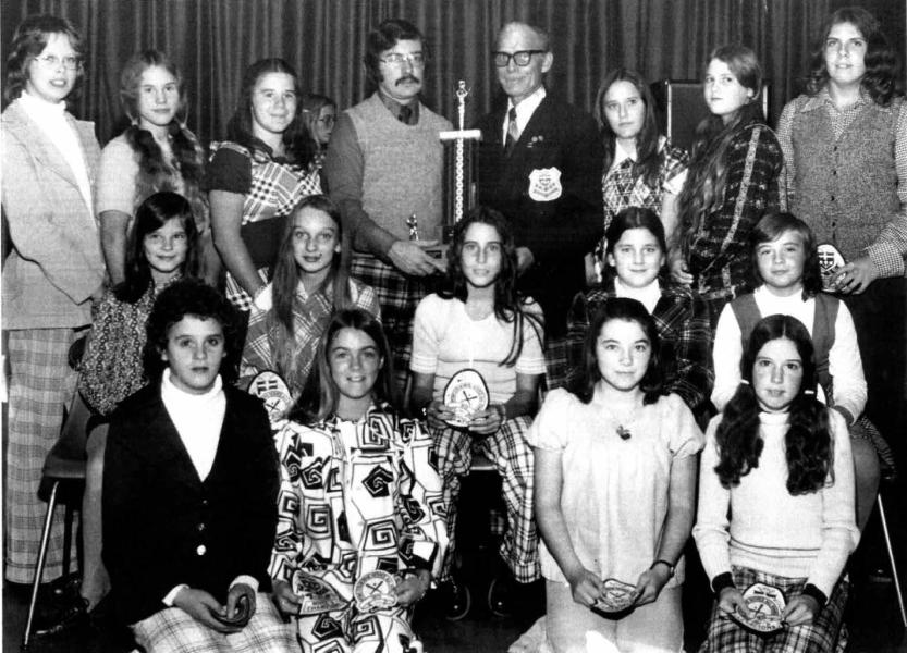 Group photo of individuals in vintage clothing, posing with awards and a sword.