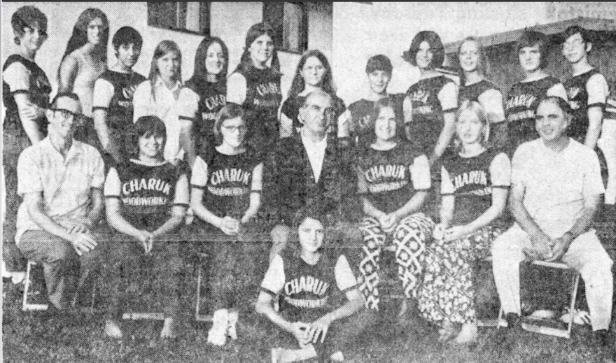 Group photo of people wearing matching shirts, posing in a team setting.