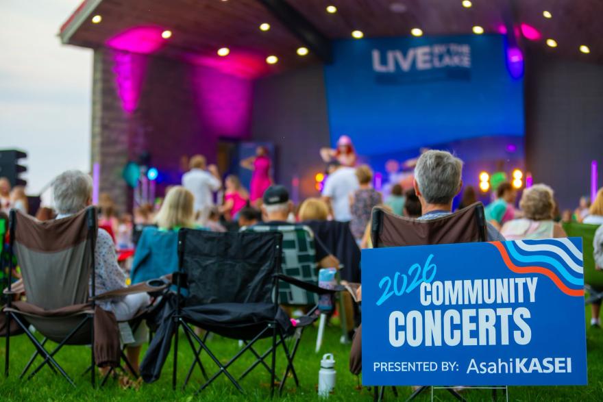 people in lawn chairs watching band on stage