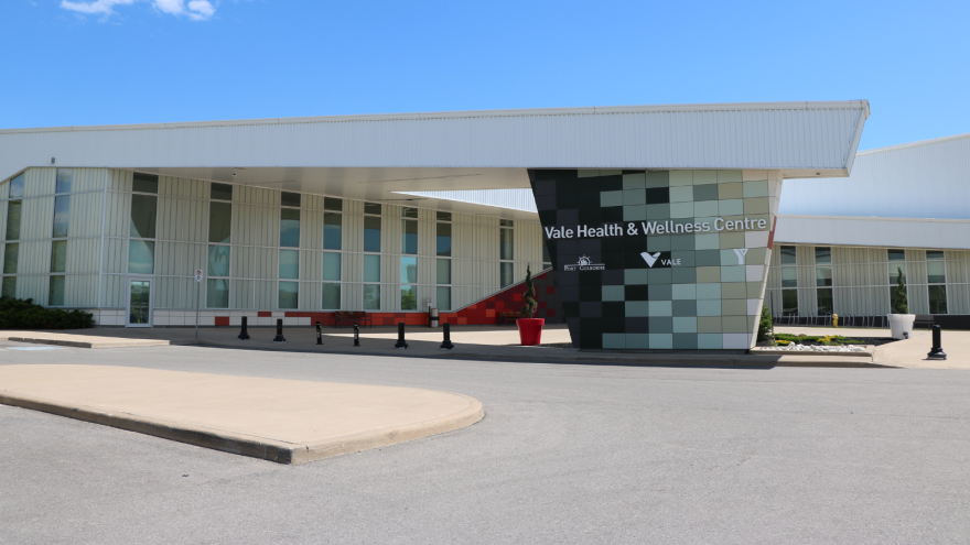 Modern building exterior with a patterned entrance and clear blue sky.