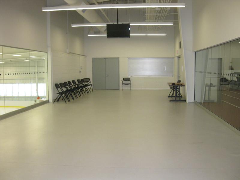 Spacious, brightly lit room with chairs arranged along one wall and glass partitions.