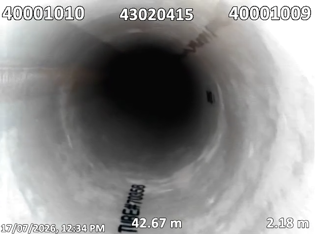 View into a dark pipe showing a distant interior with marked distance measurements.